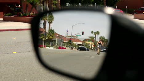 Blick-In-Einen-Rückspiegel-Eines-Geparkten-Autos-Auf-Einer-Straße-Mit-Verkehr-In-Der-Innenstadt-Von-Palm-Springs,-Kalifornien
