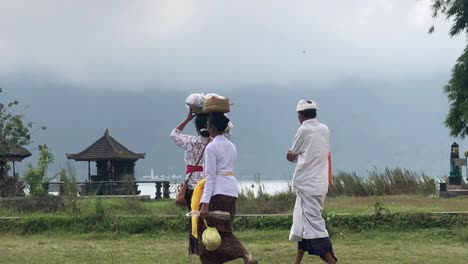 Group-of-Asian-people-walking-to-a-ceremony-at-Ulun-Danu-Bratan-temple-in-Bali,-Indonesia