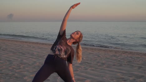 Female-blonde-doing-yoga-pose-on-the-beach