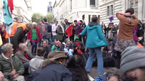 Protesters-sit-on-the-floor-and-sing-songs-during-the-Extinction-Rebellion-protests-in-London,-UK