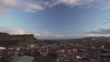 Schwenk-Vom-Calton-Hill-Mit-Blick-Auf-Die-Stadt-Edinburgh-Mit-Holyrood-Teil-Und-Arthur&#39;s-Seat-Im-Hintergrund-Mit-Wunderbarem-Sonnenuntergangslicht-Und-Wolken-In-Schottland