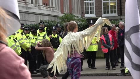 Eine-Frau-Mit-Flügeln-Tanzt-Vor-Der-Polizei-Bei-Den-Protesten-Gegen-Das-Aussterben-Der-Rebellion-In-London,-Großbritannien