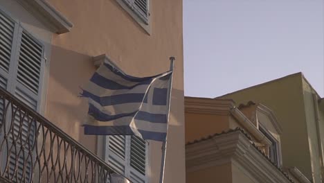 Die-Griechische-Flagge-Auf-Einem-Gebäude-Weht-In-Zeitlupe
