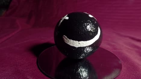 Happy-face-on-a-black-ball-make-of-clay-also-referred-to-as-the-Japanese-art-of-Dorodango
