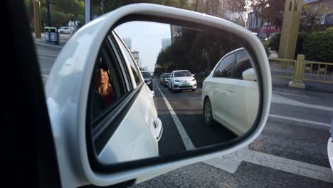Xian,-China---July-2019-:-Car-mirror-view-of-the-traffic-on-busy-street-in-the-city-of-Xian-in-summer,-Shaanxi-Province