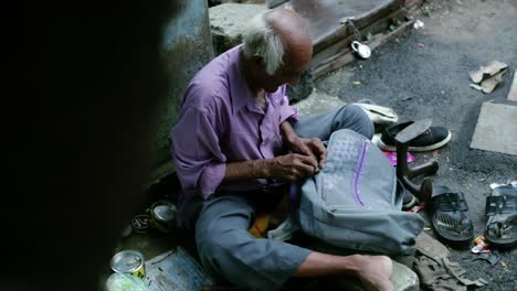 A-cobbler-repairing-slippers-of-pilgrims-by-the-roadside-in-the-morning-stock-footage-collection-7