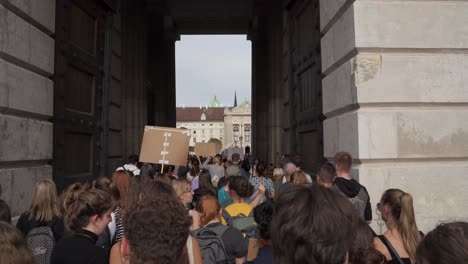 POV-inside-crowd-of-protestors-walking-through-arches-at-Hero-square-during-Fridays-for-Future-climate-change-protests