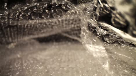 pushing-into-a-bubble-wrap-bag,-top-of-the-bag-flutters-slightly,-focused-on-the-top-third-of-the-bag