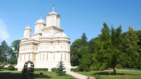 Schwenk-über-Das-Kloster-Curtea-De-Arges,-Rumänien,-Und-Seine-Gärten-An-Einem-Sonnigen-Und-Warmen-Sommertag