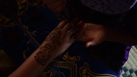 Henna-hand-tattoo-with-tradicional-ink-in-the-Sahara-Desert,-Morocco