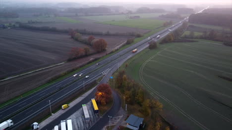 High-aerial-top-down-shot-of-parking-area-with-trucks-beside-german-motorway