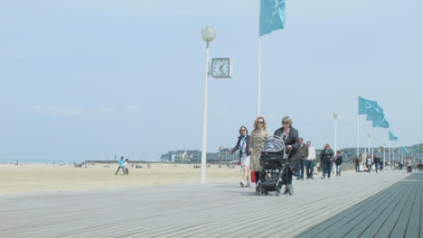 People-Walking-On-A-Sunny-Day-In-A-Beach-Side-Pathway-In-Europe