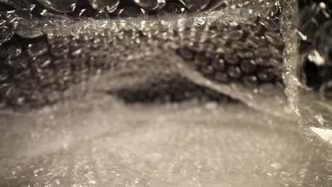 slowly-pushing-into-a-bubble-wrap-bag-all-the-way-to-the-end,-many-details-and-textures-of-the-bubbles-are-visible