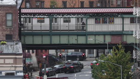 Metro-train-stops-by-the-overhead-train-station-in-the-urban-area-of-Brooklyn,-New-York