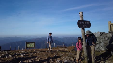 Pan-left-over-summit-and-shrine-as-morning-hikers-complete-their-travel-and-take-photos