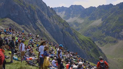 big-crowd-watching-the-tour-de-france-with-a-big-green-mountain-scenery-background