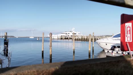 Handheld-shot-through-a-guard-fence-of-a-luxury-yacht-anchored-at-the-Sag-Harbor-Marina