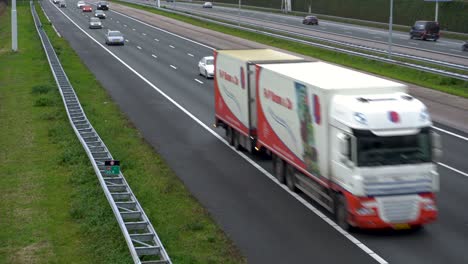 Busy-highway-in-Netherlands,-tilt-reveal-from-bridge-over-road