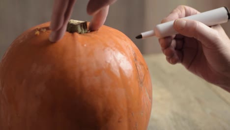 Drawing-on-a-pumpkin-for-a-Halloween-Jack-o-Lantern