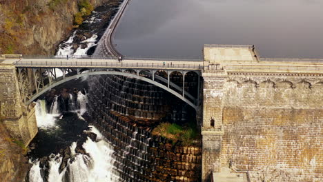pedestal-shot-up-as-the-drone-camera-tilts-down---dolly-out-away-from-the-waterfalls---overpass-at-the-New-Croton-Dam-in-Westchester-County,-NY