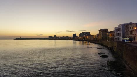 Beautiful-Time-Lapse-view-of-the-Old-Havana-City,-Capital-of-Cuba,-by-the-Ocean-Coast-during-a-vibrant-sunny-and-colorful-sunrise