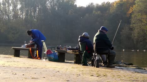 Gruppe-Von-Rentner-Hobby-Bootsclub-Männern,-Die-Im-Herbstpark-Sitzen-Und-Ihre-Boote-Für-Das-Segeln-Auf-Dem-Parksee-Vorbereiten