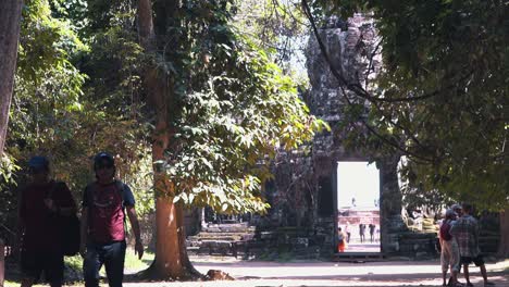 Turistas-Caminando-Por-Un-Camino-Arbolado-A-Través-De-Los-Templos-De-Angkor-Wat