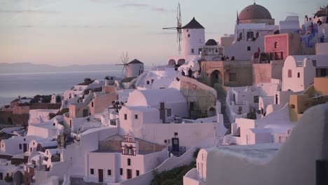 Wide-reveal-shot-of-the-scenic-coastal-village-Oia-at-Santorini-during-a-romantic-sunset