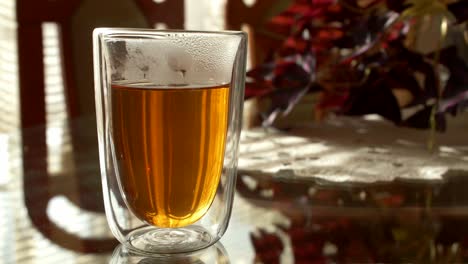Einen-Löffel-Honig-In-Ein-Durchsichtiges-Glas-Tee-Geben-Und-Umrühren