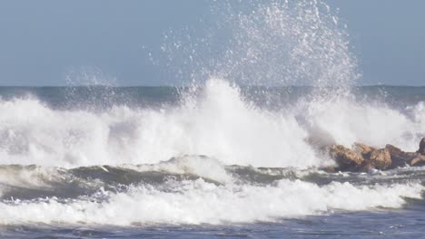 Stormy-seas-breaking-on-rocks,-slow-motion-seascape