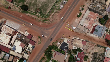 Luftdrohne-Aus-Der-Vogelperspektive-Auf-Die-T-Kreuzung-Auf-Der-Kololi-Road-In-Serekunda,-Gambia,-Afrika-Mit-Fließendem-Verkehr-Und-Autos