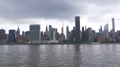 Establishing-shot-of-East-Side-Manhattan-with-the-East-River-and-Roosevelt-Island-in-the-foreground-on-a-cloudy-summer-day