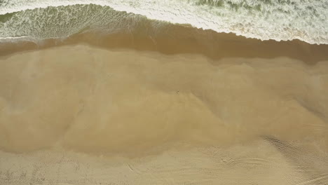 Schaumige-Wellen,-Die-An-Der-Sandigen-Sturmküste-Spritzen,-In-Der-Nähe-Des-Campingplatzes-Praia-Da-Gale-In-Portugal---Luftdrohnenaufnahme