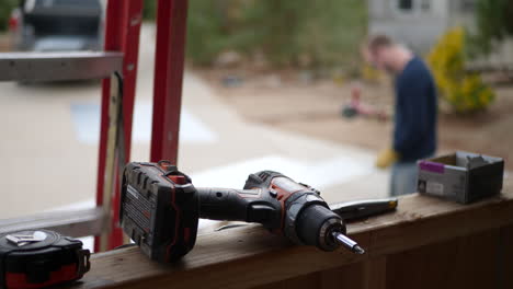 A-construction-worker-grinding-metal-and-making-sparks-fly-on-a-job-site-with-a-drill-and-tools-in-the-foreground