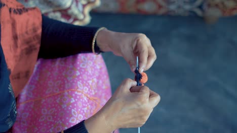 Indian-woman's-hands-knit-with-red-and-black-wool-and-needle-crafts
