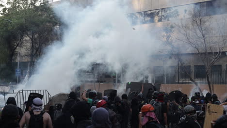 Rioters-throw-stones-at-police-as-clouds-of-tear-gas-float-into-the-crowd