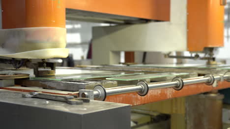 Drilling-a-hole-into-glass-panel-on-a-modern-orange-machine-with-a-moving-table