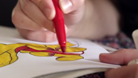 closeup-of-child-hands-using-a-red-marker-to-color-in-art