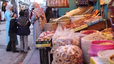 Vista-De-La-Calle-De-Hombres-Y-Mujeres-Locales-Comprando-En-Essaouira,-Marruecos-Durante-El-Día