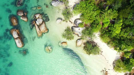 Secret-exotic-beach-through-limestone-cliffs-alongside-white-sandy-beach-of-tropical-island-coastline-in-Thailand