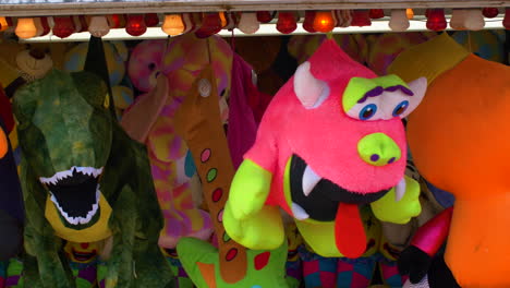 Pinkie-and-Dinosaur-stuffed-animals-hang-on-display-at-a-carnival-above-the-game-station