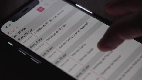 Finger-tapping-on-the-screen-of-an-Iphone-and-opening-the-Calendar-app