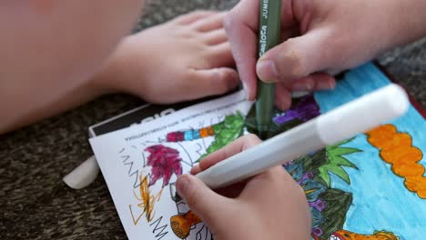 Child-coloring-in-book-and-sharing-time-with-parent