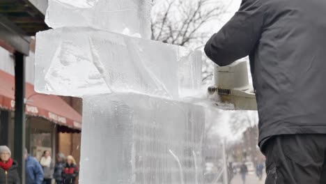Static-close-up-of-sculptor-cutting-ice-blocks-with-chainsaw