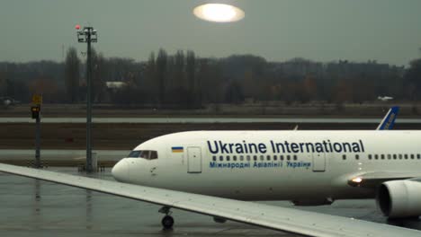 Eine-Nahaufnahme-Eines-Ukrainischen-Internationalen-Flugzeugs,-Das-Gerade-Auf-Dem-Flughafen-Gelandet-Ist-Und-Zu-Seiner-Flughülle-Fährt