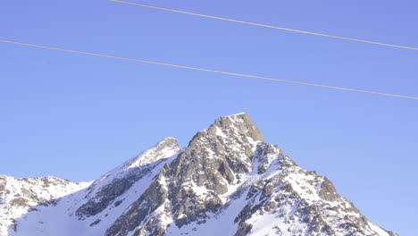 Rot-Gefärbte-Skiliftsessel-Kreuzen-Sich-In-Der-Mitte,-Während-Sie-Sich-In-Entgegengesetzte-Richtungen-Bewegen