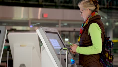 Niedrige-Nahaufnahme-Einer-Frau-Mit-Reisepass-Und-Smartphone-In-Der-Hand,-An-Einem-Flughafen-Check-in-Terminal-Und-Beim-Einchecken