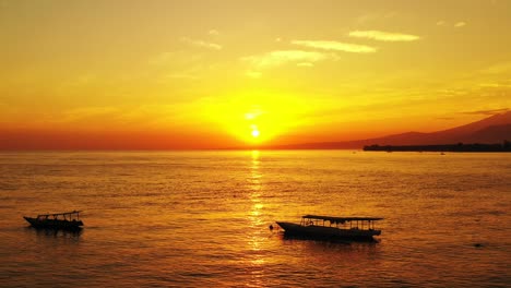 Wunderschöner-Goldener-Sonnenuntergang,-Der-Sich-Auf-Dem-Wasser-Mit-Einem-Malerischen-Blick-Auf-Die-Berge-Und-Verankerten-Boote-Widerspiegelt