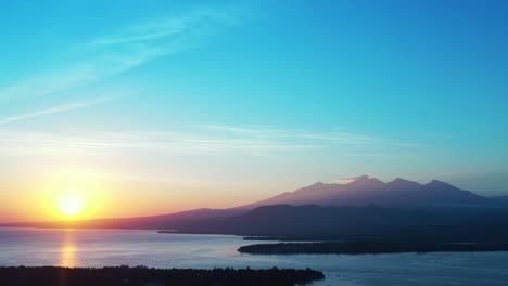 Schöner-Goldener-Sonnenaufgang-An-Einem-Frühen-Morgen-über-Bergen-Und-Im-Wasser-Reflektiert