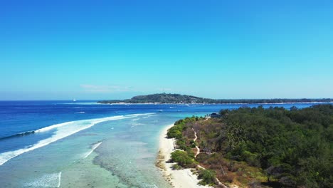 Lombok,-Bali,-Indonesia,-Gili-islands-surrounded-by-crystal-clear-turquoise-sea-water-and-deep-sea-ocean-with-boats